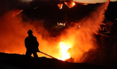 Three flames are tearing through the suburbs of Los Angeles, forcing thousands to leave their homes.